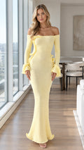 Front view of woman wearing pastel yellow off-shoulder fluted sleeve mermaid knit maxi dress