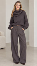 Full front view of model wearing charcoal grey ribbed cowl neck sweater with matching tailored wide-leg trousers