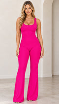 Front view of model wearing a hot pink sleeveless flare leg jumpsuit with scoop neckline