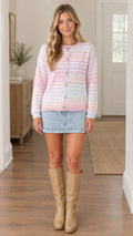 Full front view of model wearing pastel pink striped knit cardigan sweater with denim skirt and boots