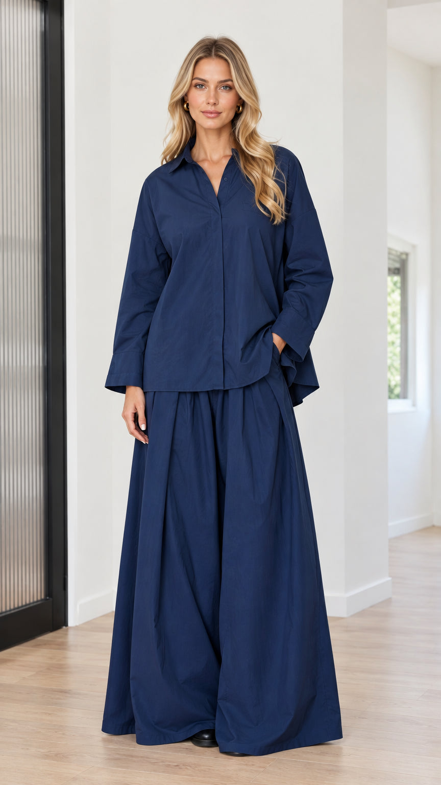 Front full view of woman wearing navy blue button-down shirt and pleated wide-leg pants set