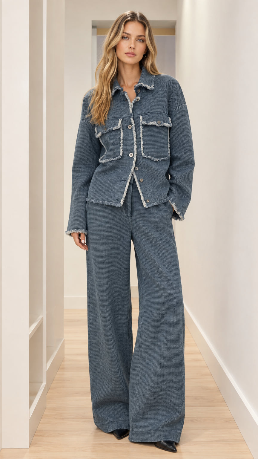 Front full-length view of woman wearing slate blue textured frayed jacket and wide leg pants set