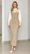 Front full-length view of model wearing beige corset vest top with satin blouse and matching maxi skirt
