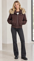 Women's brown faux fur trimmed hooded bomber jacket front view with flare jeans
