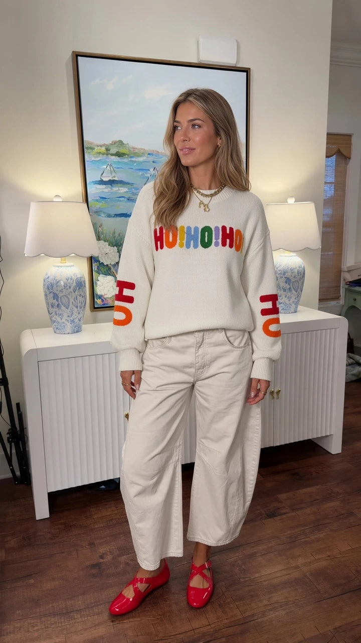 Front full view of woman wearing white Ho Ho Ho Christmas crewneck sweater with wide-leg pants