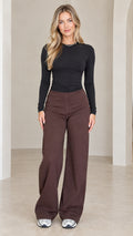 Front view of model wearing black ruched long sleeve top and chocolate brown wide leg pants set