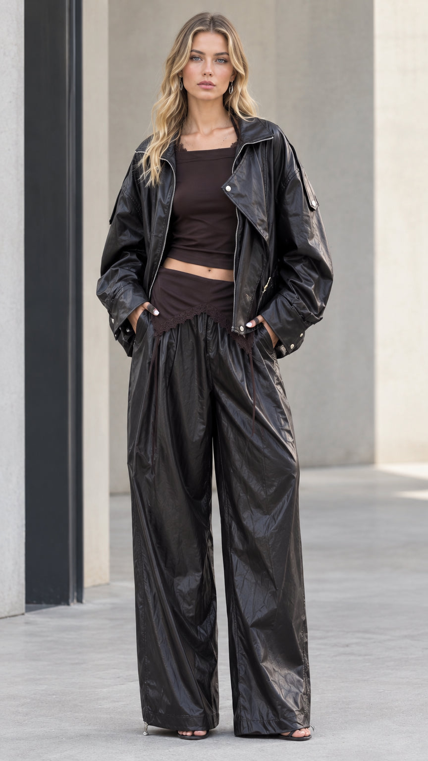 Full front view of model wearing black metallic sheen zip jacket and matching wide leg pants
