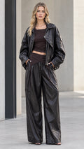 Full front view of model wearing black metallic sheen zip jacket and matching wide leg pants