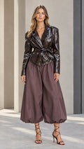 Front full-length view of model wearing chocolate brown glossy belted blazer and matching balloon pants set