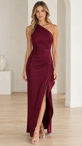 Front full-length view of woman in burgundy one-shoulder ruched maxi dress with high side slit