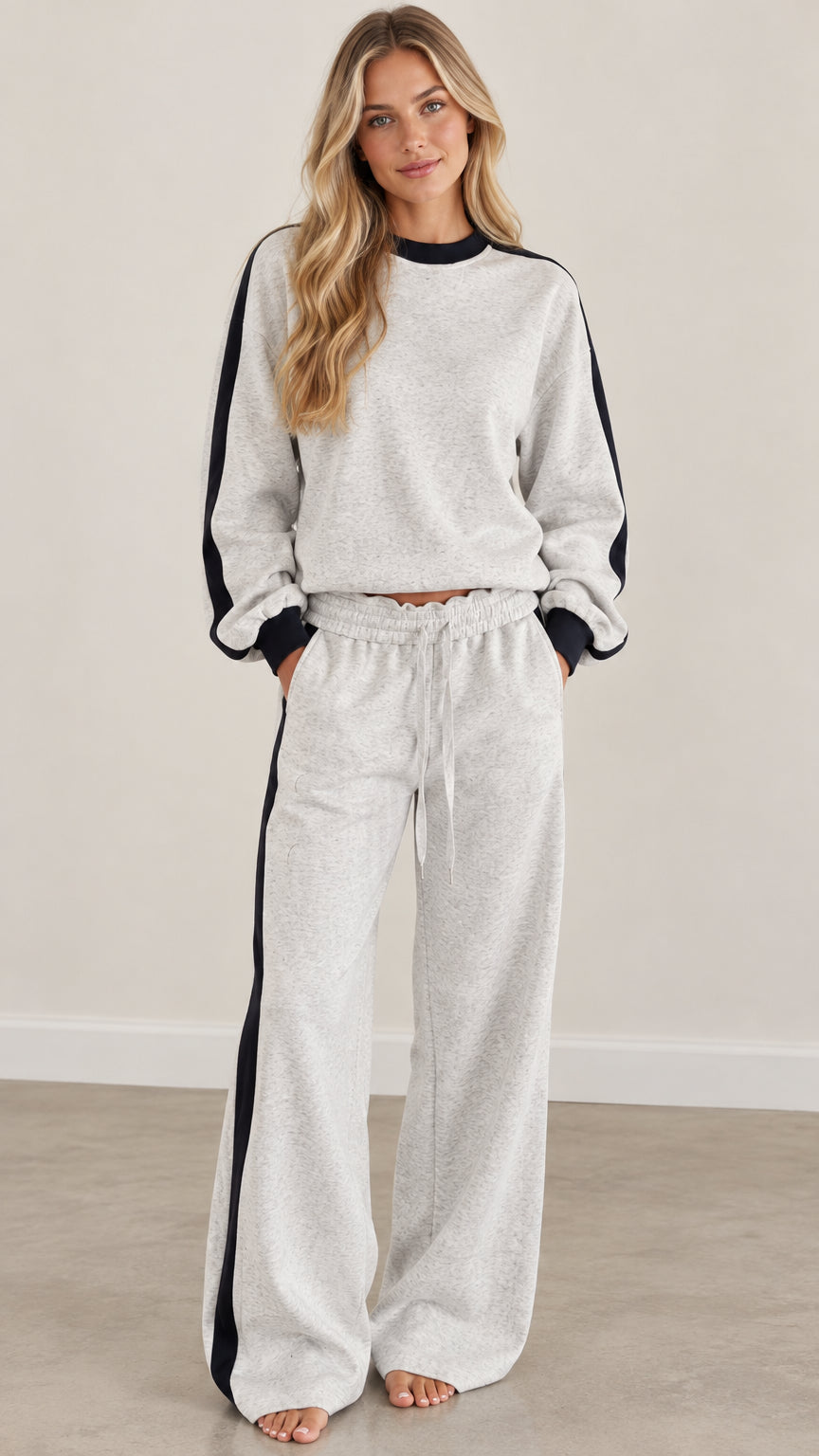 Full front view of model wearing heather gray two-piece sweatshirt and wide-leg pants set with black side stripe