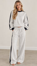 Full front view of model wearing heather gray two-piece sweatshirt and wide-leg pants set with black side stripe