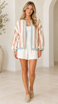Front full-length view of woman wearing camel striped open-front balloon sleeve cardigan jacket with white shorts