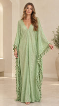 Front view of woman wearing sage green shimmer sequin kaftan maxi dress with tassel trim