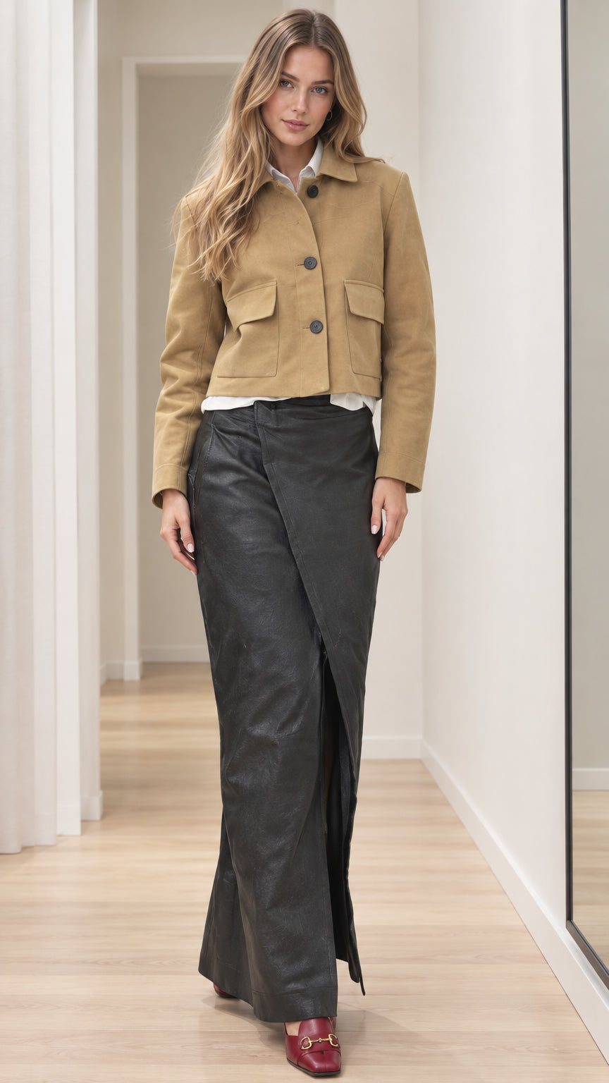 Front full view of woman wearing tan cropped button-front jacket with flap pockets and long black wrap skirt