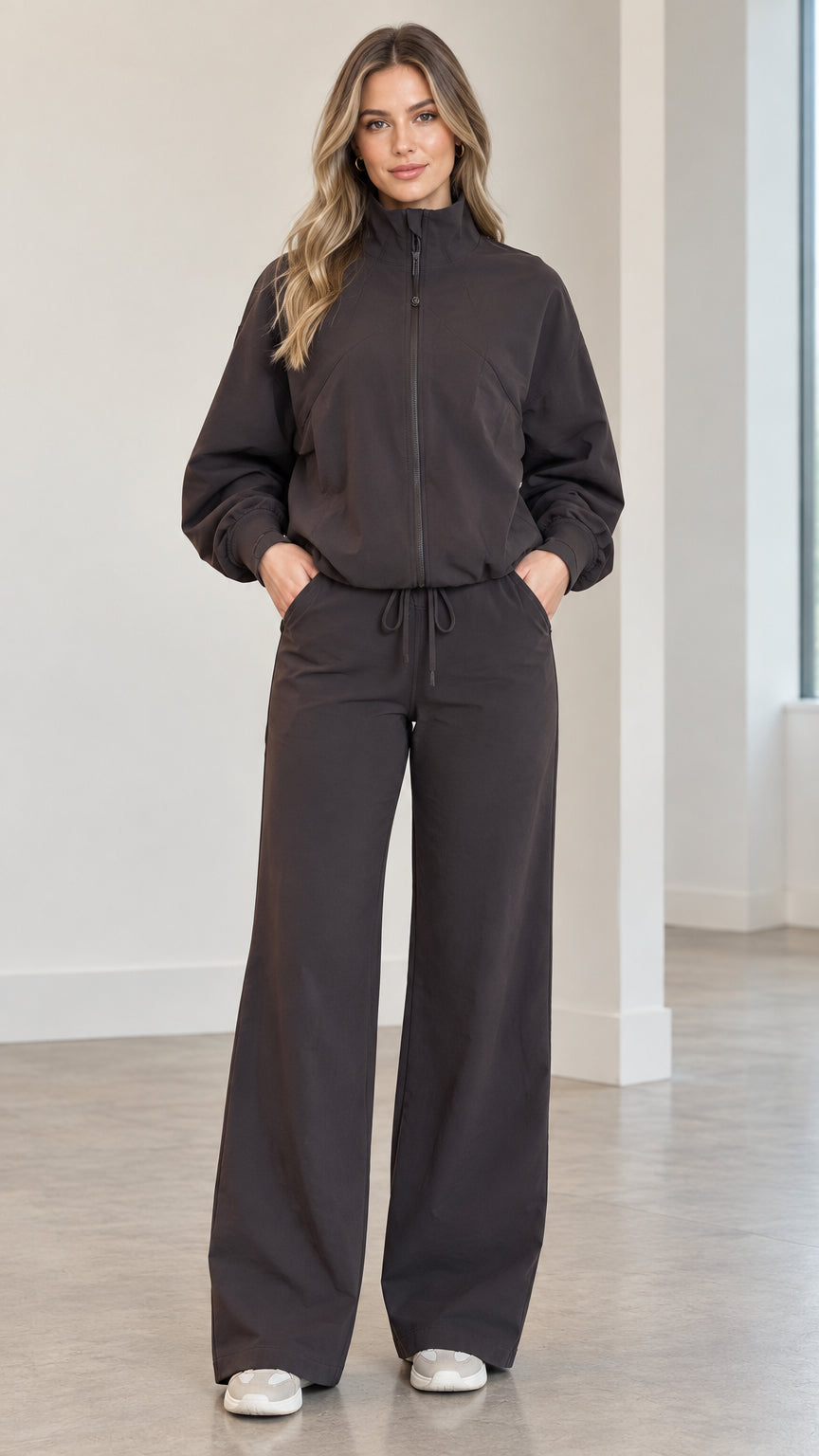Front full view of woman wearing charcoal zip-up track jacket and matching wide-leg pants set