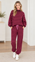 Full front view of woman wearing burgundy striped sweatshirt and matching jogger pants loungewear set