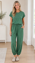 Front full view of woman wearing green short sleeve drawstring jogger jumpsuit with pockets