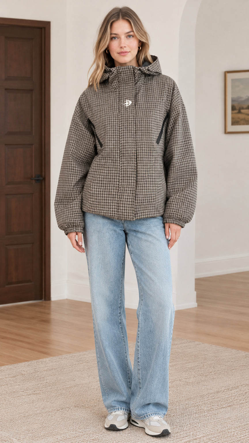 Front view of model wearing brown houndstooth hooded jacket with light wash jeans