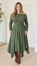 Front full-length view of woman wearing an olive green off-the-shoulder handkerchief midi dress with brown boots