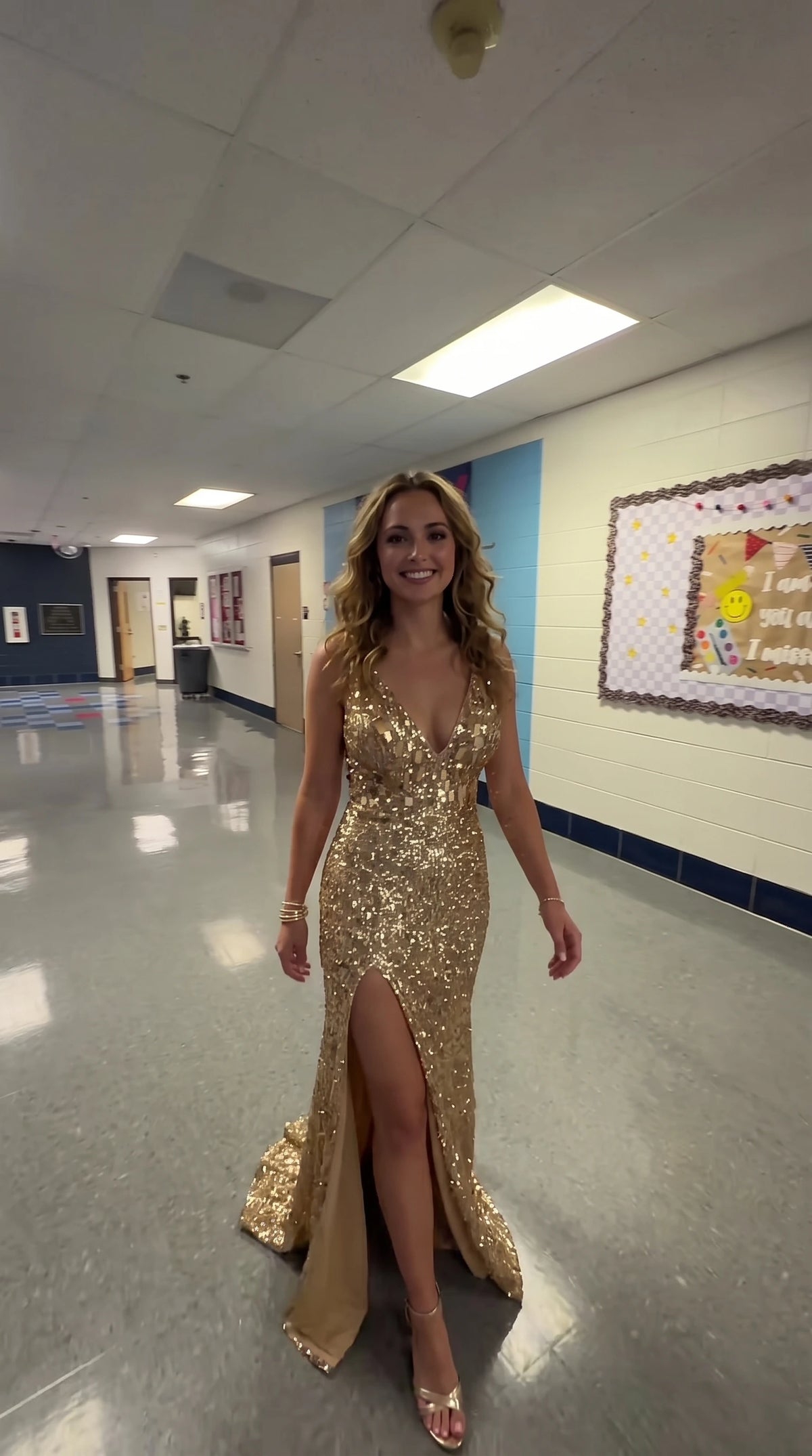 Model wearing gold sequin plunging V-neck evening gown with high leg slit