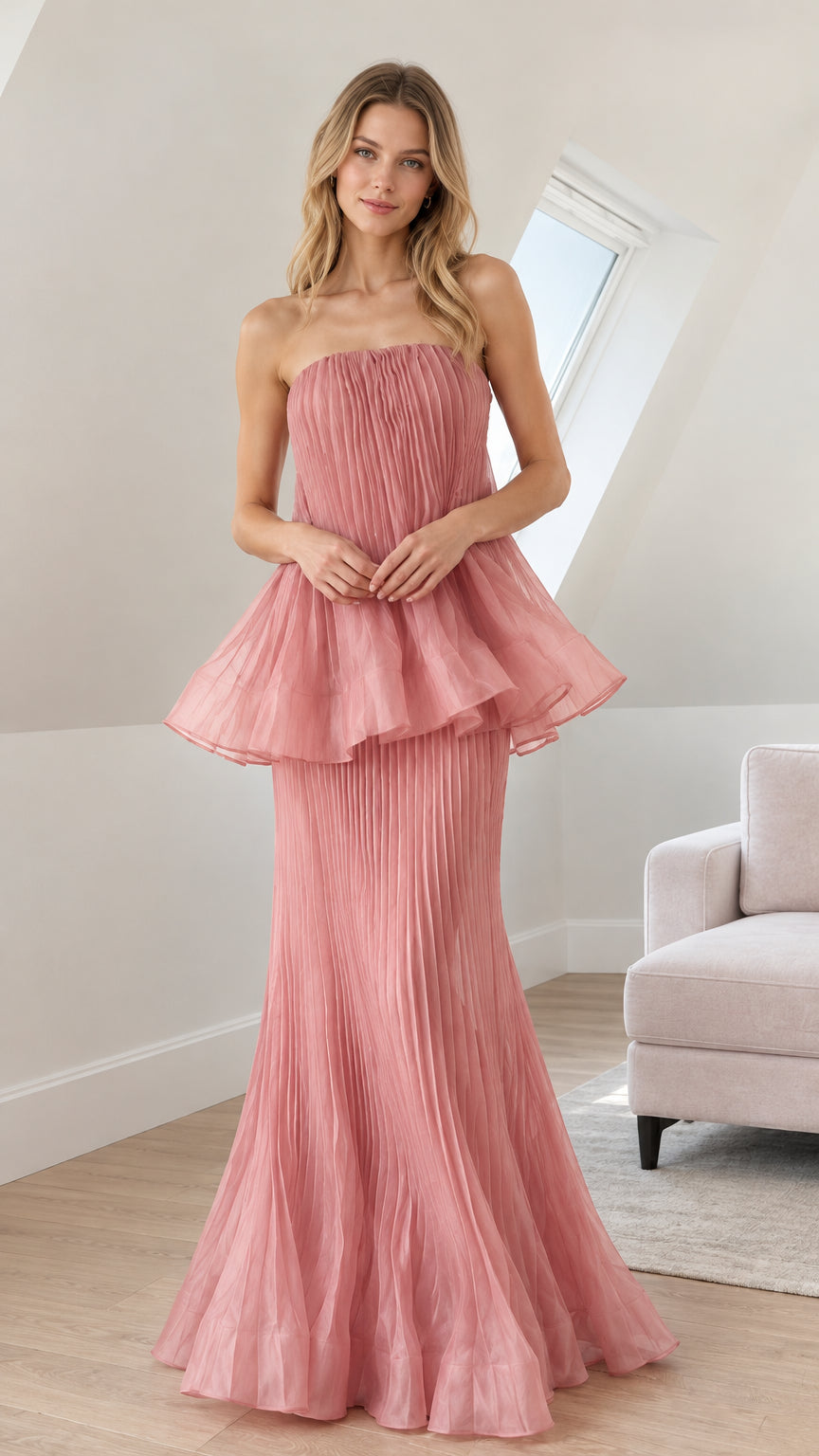 Front view of woman wearing dusty rose strapless pleated peplum maxi gown