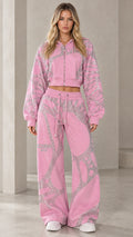 Front view of model wearing pink rhinestone web cropped hoodie and wide-leg sweatpants set