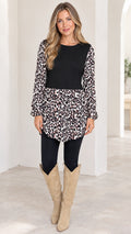 Front view of model wearing black and leopard print long sleeve tunic top with black leggings and knee-high boots