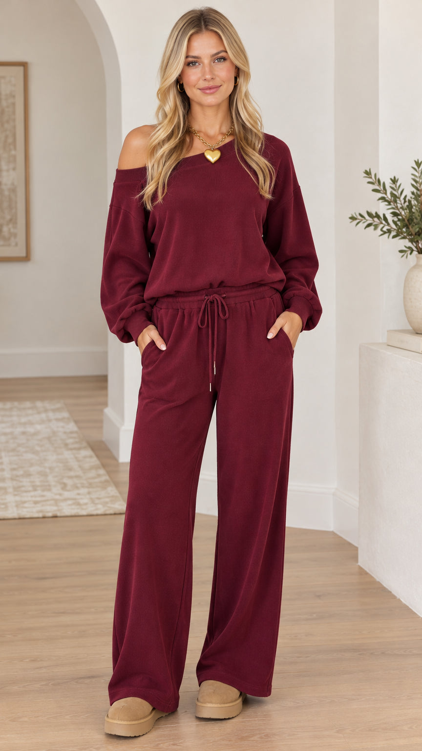 Full-length front view of woman wearing burgundy off-the-shoulder top and wide-leg lounge pants set