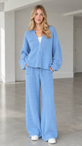 Front full view of woman wearing light blue ribbed knit zip-up cardigan and wide-leg pants set