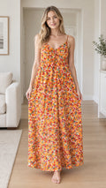 Front view of woman wearing orange floral spaghetti strap backless maxi dress