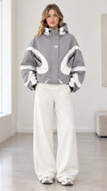 Front view of model wearing grey and white colorblock hooded jacket with wide-leg white pants