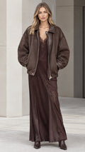 Model wearing brown oversized bomber jacket and matching brown lace-trim maxi slip dress set - front view