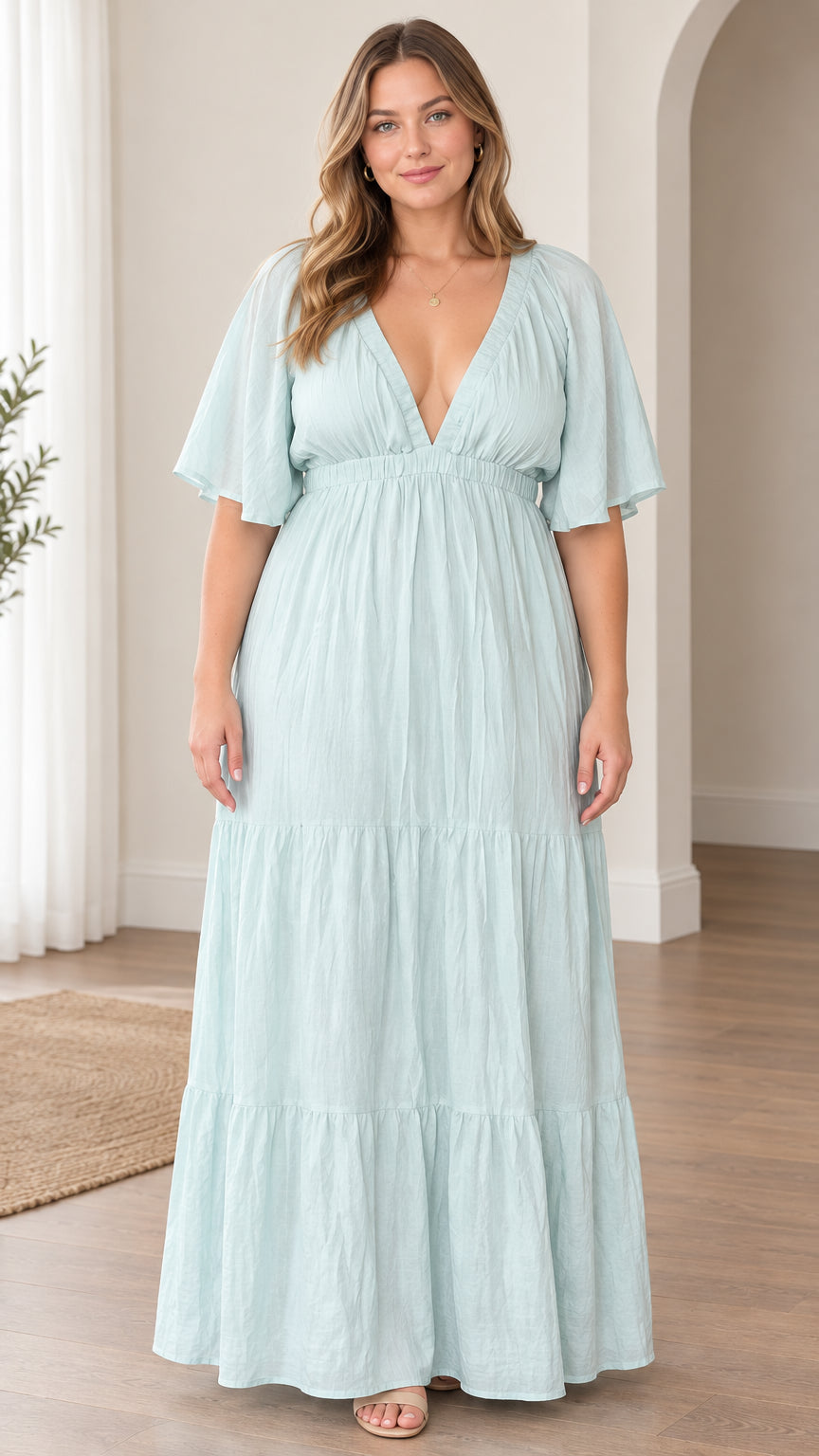 Full front view of model wearing light blue plunge V-neck tiered maxi dress with flutter sleeves