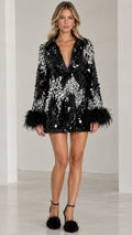 Front view of model wearing black sequined plunge mini dress with black feather cuffs