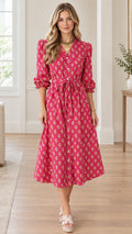 Full front view of model wearing hot pink floral print button-front midi dress with tie waist