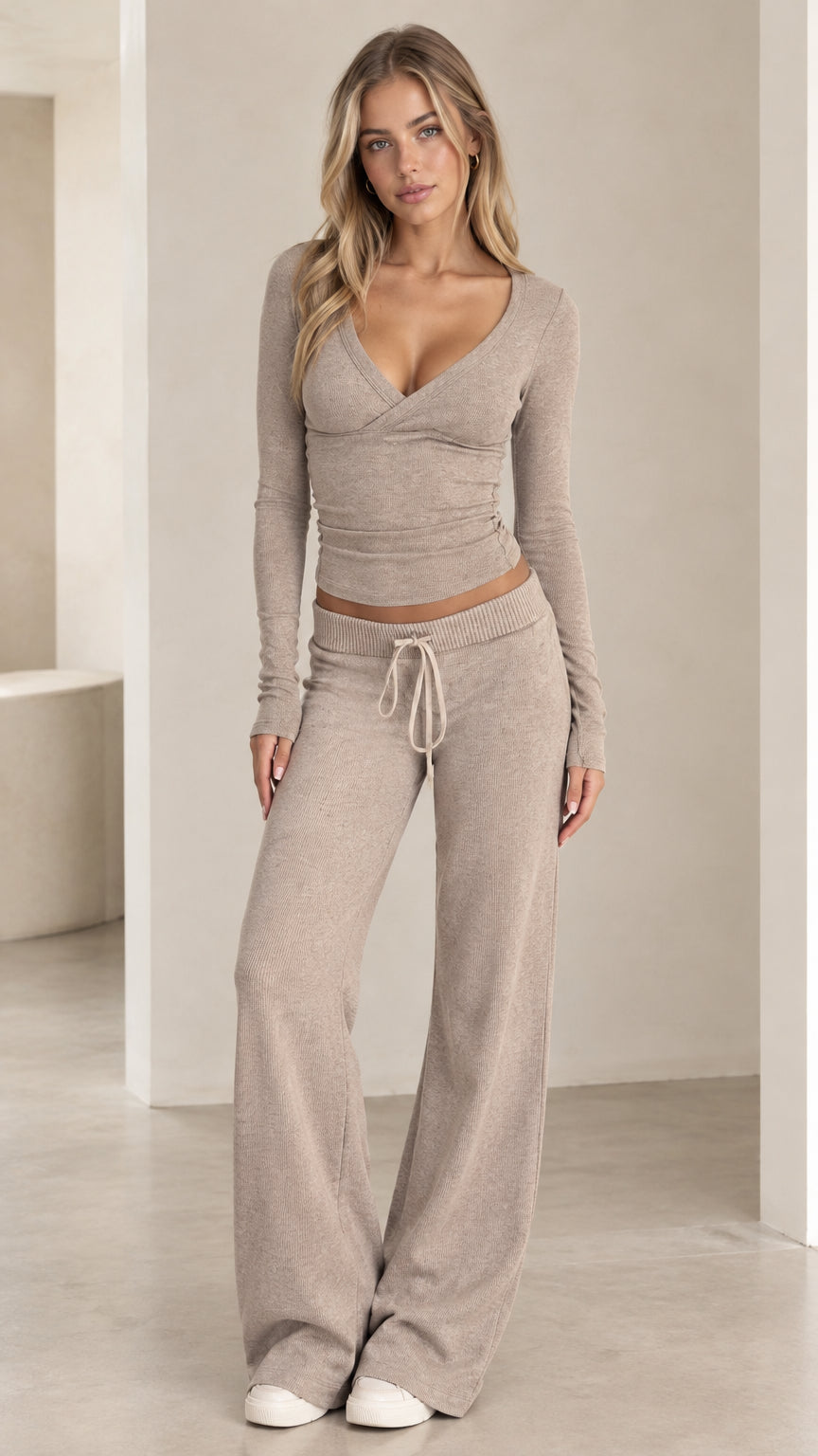 Full front view of model wearing beige ribbed knit two-piece set with crossover top and wide-leg pants