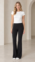 Full front view of model wearing white short-sleeve fitted t-shirt and black high-waisted flare pants