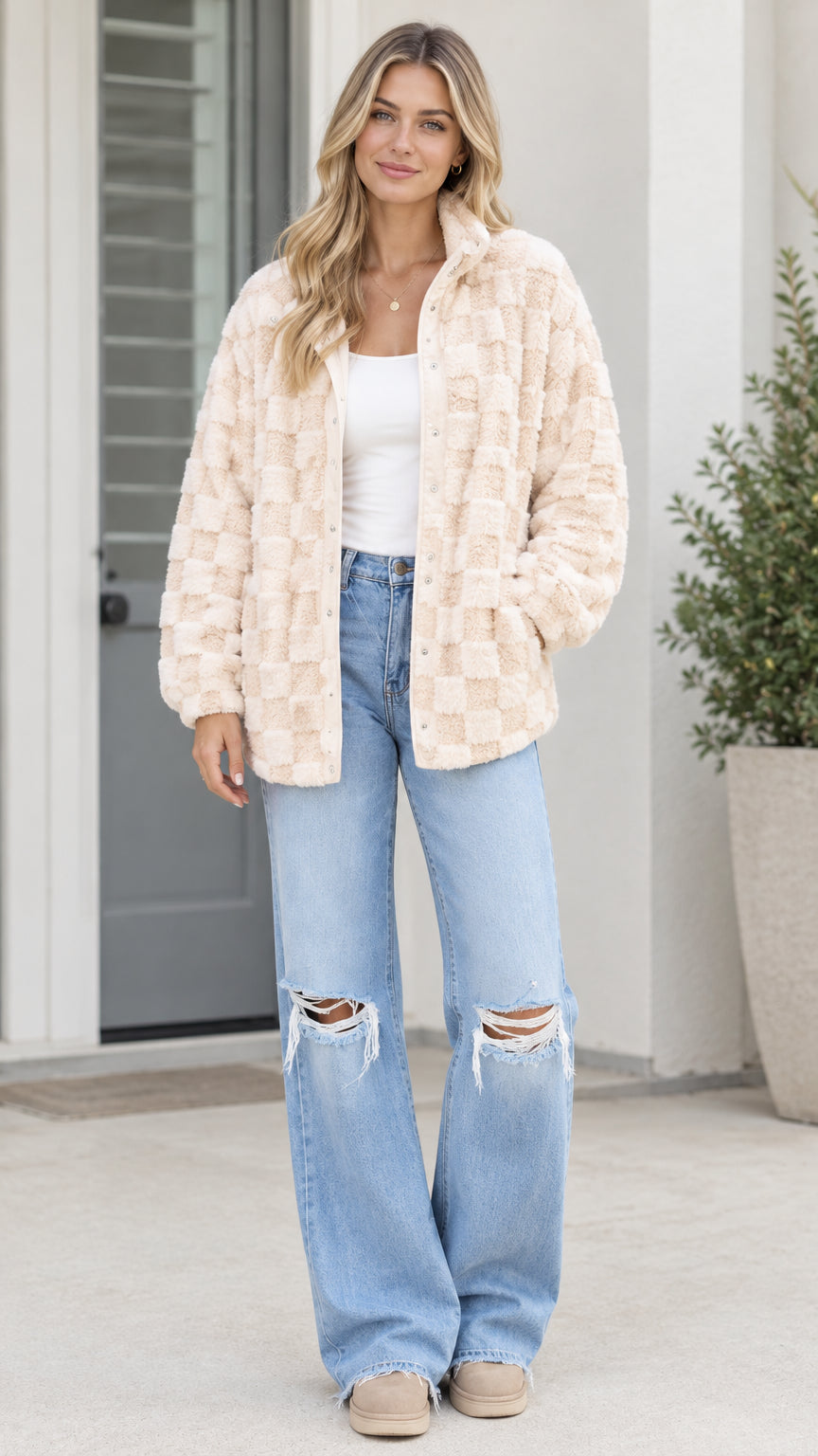 Front view of model wearing beige textured checkerboard plush fleece jacket with wide leg jeans