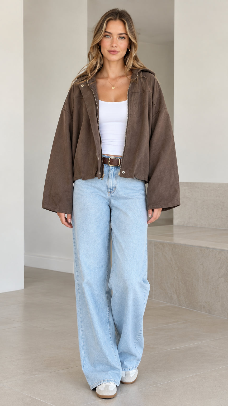 Front view of model wearing brown washed hooded cropped jacket with wide sleeves and jeans
