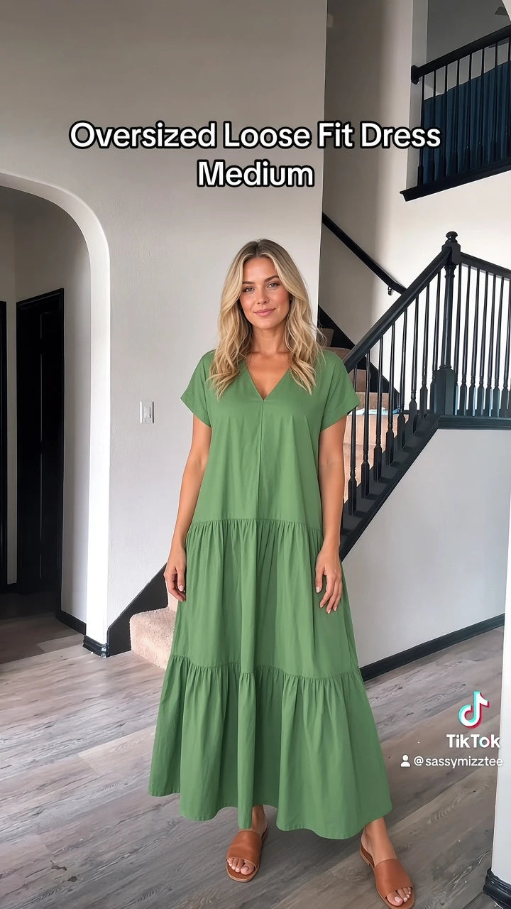 Front full-length view of woman wearing oversized green V-neck tiered maxi dress