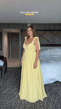 Front view of woman wearing yellow sweetheart maxi dress with tie shoulder straps
