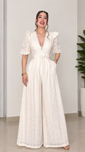 Front view of woman wearing ivory lace wide-leg belted jumpsuit with V-neckline
