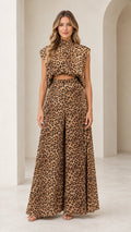 Front full view of woman wearing brown leopard print sleeveless crop top and wide-leg pants set