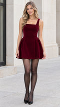 Front full-length view of model wearing burgundy square neck velvet mini dress