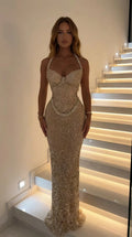 Front view of woman wearing gold rhinestone embellished halter sweetheart maxi evening gown