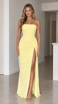 Front full view of woman wearing yellow strapless ruched maxi dress with high side slit