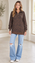 Front view of model wearing brown leopard print quarter-zip sweatshirt with light blue jeans