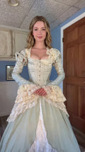 Front view of woman wearing sage green Victorian corset ball gown with cream lace trim
