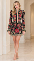 Front view of model wearing black floral embroidered long sleeve mini dress with plunging keyhole neckline